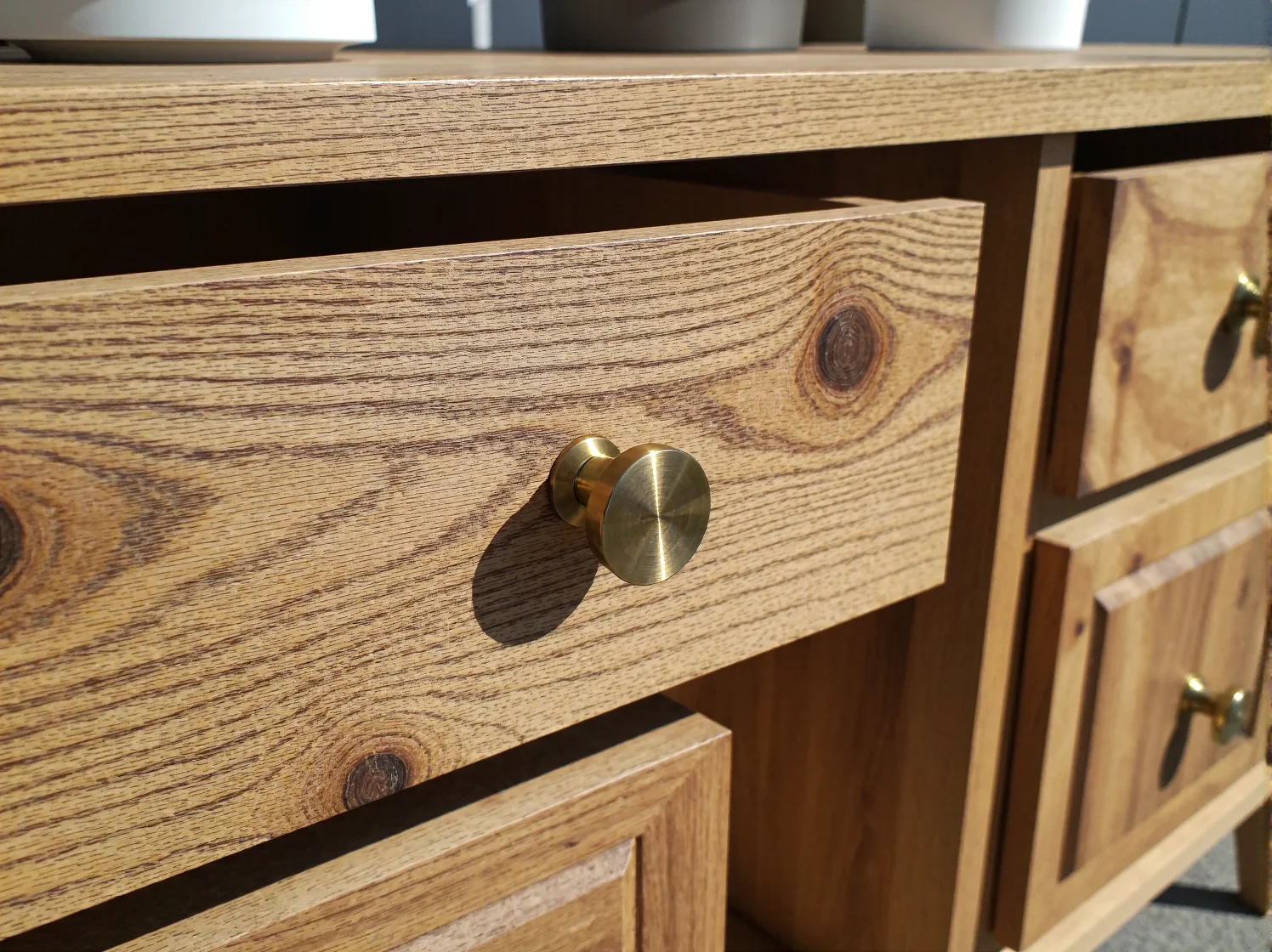 Drewniana powierzchnia w połowie oczyszczona z farby, pokazująca efekt działania narzędzi do renowacji mebli.