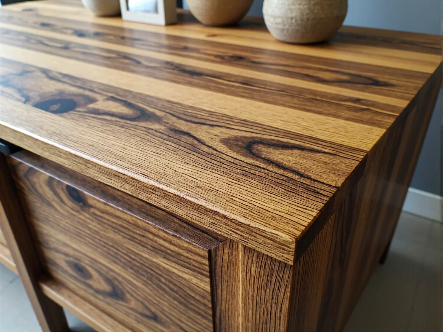 Efekty szlifowania drewna przed malowaniem – gładka powierzchnia blatu po renowacji.